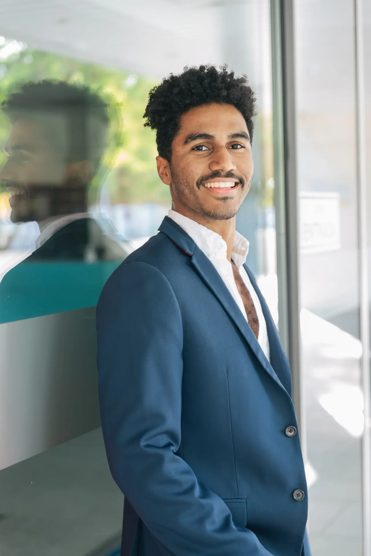 happy-young-black-man-in-blazer-standing-near-glas-2025-01-09-05-29-40-utc.webp