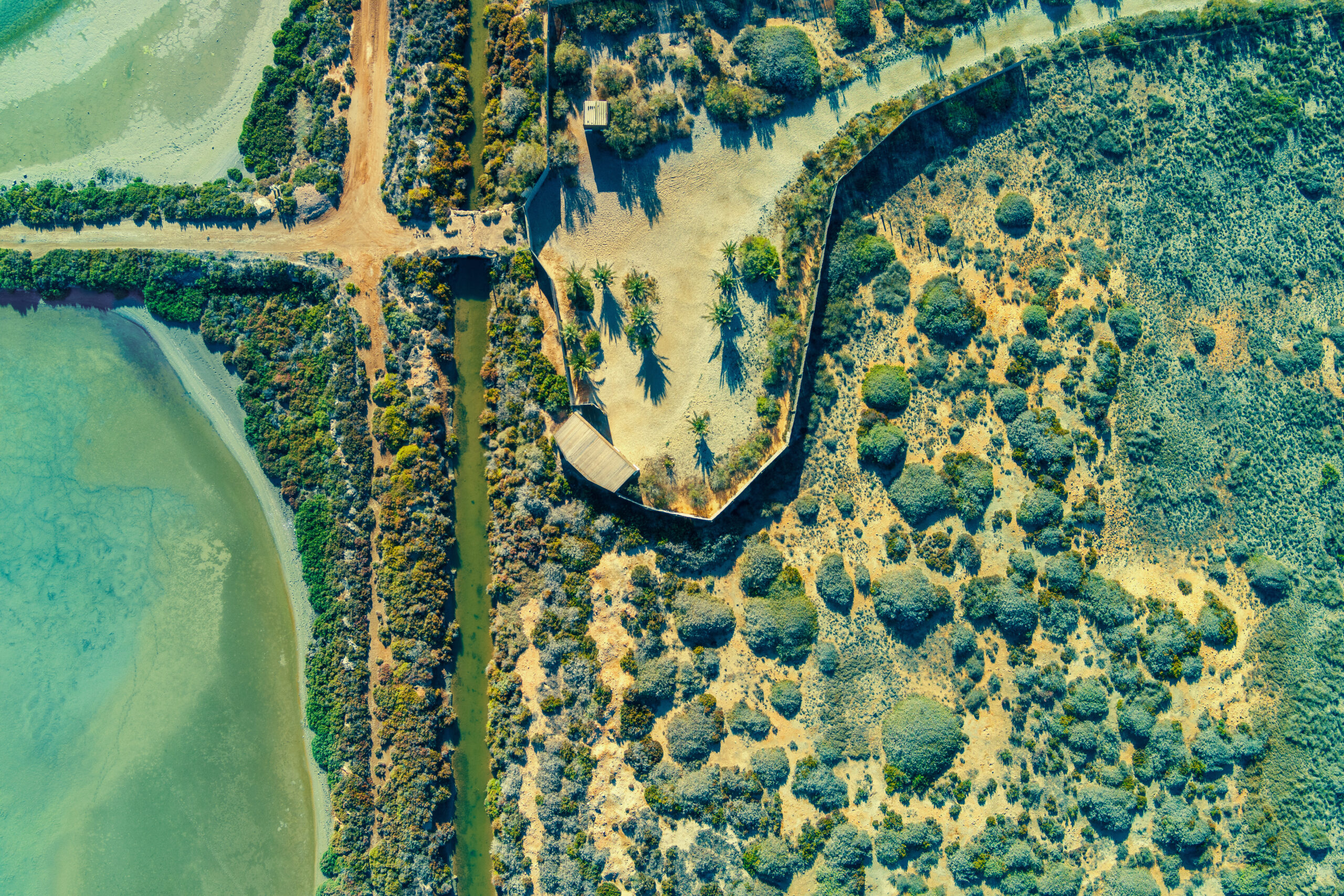 Aerial view of a coastal salt lake, shoreline, and surrounding vegetation